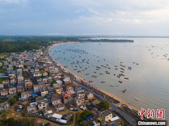 图为航拍海南环岛旅游公路紧邻新兴港渔港穿过澄迈县包岸村。林士杰 摄 图为航拍海南环岛旅游公路紧邻新兴港渔港穿过澄迈县包岸村。林士杰 摄