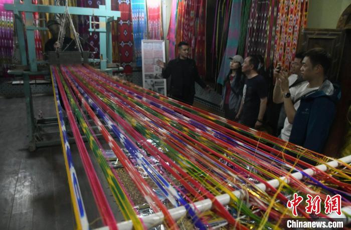 图为5月12日,游客在喀什地区莎车县非遗博览园里参观艾德莱斯绸纺织工艺。 图为5月12日,游客在喀什地区莎车县非遗博览园里参观艾德莱斯绸纺织工艺。