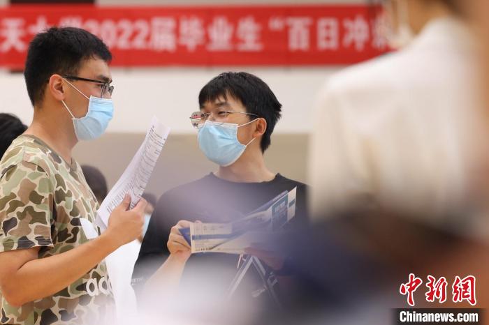 资料图:招聘会上大学生相互交流。泱波 摄 资料图:招聘会上大学生相互交流。泱波 摄