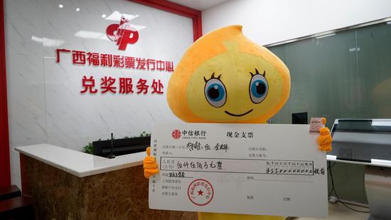 幸运购彩者成先生手持中奖彩票合影
