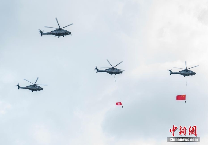 7月1日，庆祝香港回归祖国26周年升旗仪式在金紫荆广场举行。图为直升机护卫中国国旗和香港特别行政区区旗通过广场上空。中新社记者 侯宇 摄