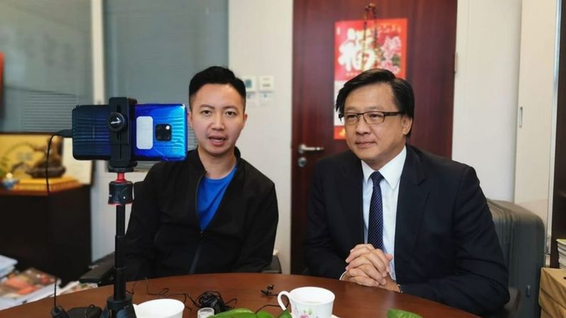 桌子前坐着穿西装的人描述已自动生成