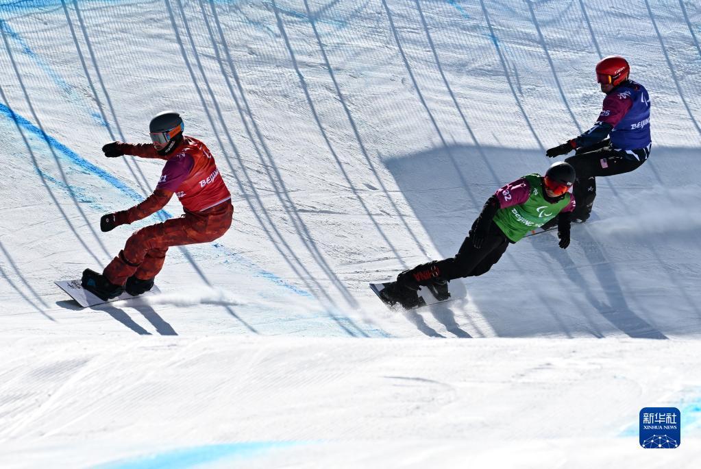3月7日，中国选手武中伟（中）在北京冬残奥会单板滑雪男子障碍追逐LL1级比赛中，最终他获得季军。新华社记者宋彦桦摄