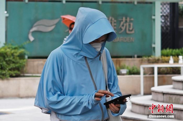 资料图：出行市民包裹严实防晒防暑。 中新社记者 殷立勤 摄