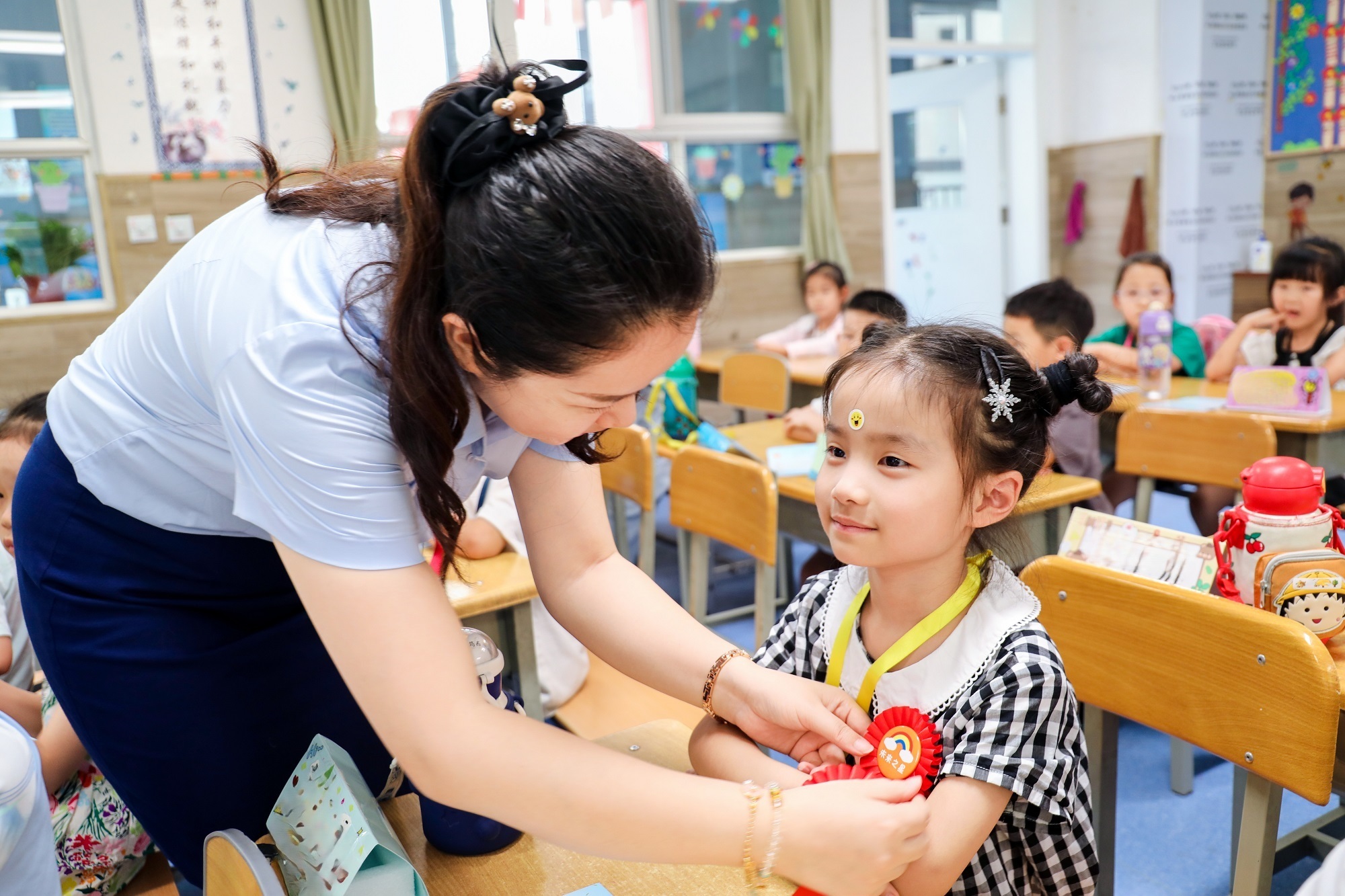 老师为新生带上奖励的“小勋章”（央广网发 西安高新第八小学供图）