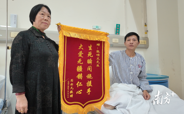 石先生和他妈妈展示着准备的锦旗。